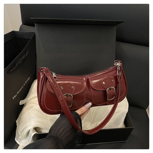 Détail de ce sac baguette en cuir verni bordeaux avec deux poches avant symétriques