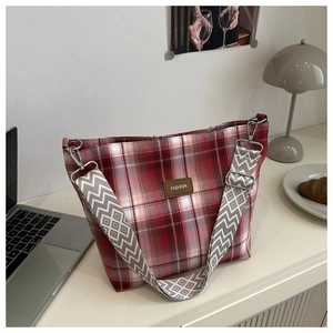 Detail of red checkered canvas tote with wide geometric strap and fashion label