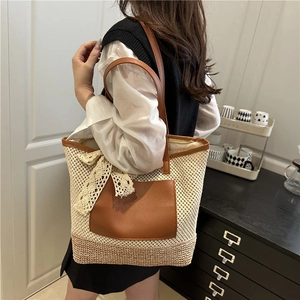 Beige woven bucket tote bag with lace bow detail and brown leather straps for women