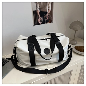 Large white travel tote bag with black straps on a desk with laptop and coffee