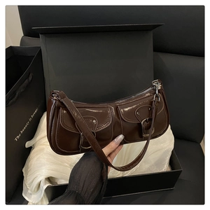 Vue détaillée du sac baguette en cuir verni marron foncé avec poches à boucles en métal