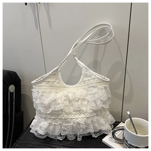 Dettaglio di borsa tote in pizzo bianco con balze a pieghe in stile romantico francese