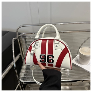 Close-up of bowling bag with number 96 patch and red stripes held by hand indoors