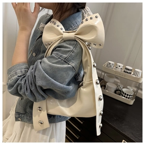 Détail du sac croissant en cuir blanc crème avec rivets argentés et bandoulière à nœud