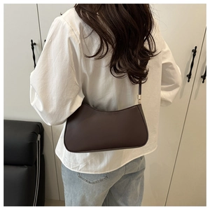 Detail of a vintage dark brown crescent leather shoulder bag with adjustable strap