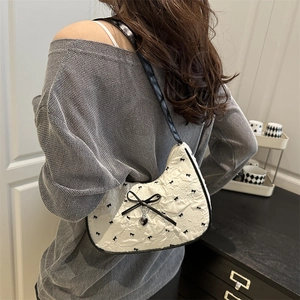 Chic off-white crescent underarm bag with black bow embroidery and heart pendant