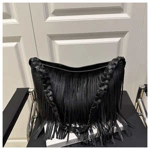 Vue détaillée de la bandoulière en cuir tressé et des franges de ce sac cabas noir