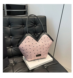 Close-up of pink textured tote bag with bow embroidery and contrast black piping