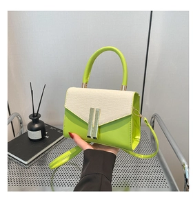 Détail d'un sac à main en cuir vert tilleul avec rabat tissé crème et boucles dorées