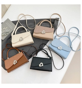 Verschiedene Handtaschen aus Leder mit herzförmiger Metallschnalle und Webstruktur