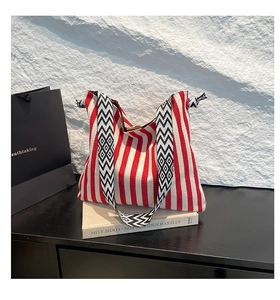 Detail of red and white striped tote bag with geometric pattern woven wide shoulder strap