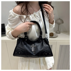 Detail of black gothic crossbody bag with silver cross charm and metal chain accents