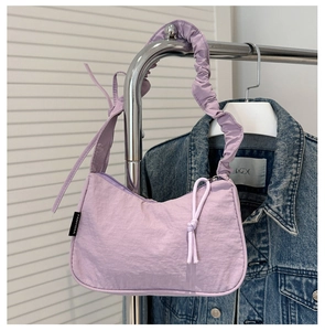 Detail of lavender nylon crescent bag featuring side ribbon bow and wrinkled shoulder strap