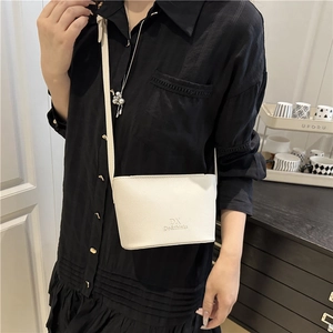 White minimalist bucket bag with black lettering and textured finish for summer casual style