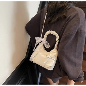 Detailed back view of a white bow shoulder bag with ruffled handle and lace decor
