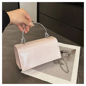 Detail der hellrosa Lackledertasche mit silbernem Rundgriff aus Metall und Kettenriemen