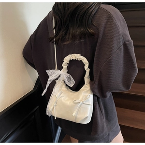 Détail du sac nuage blanc crème avec poignée plissée et nœud en dentelle délicat