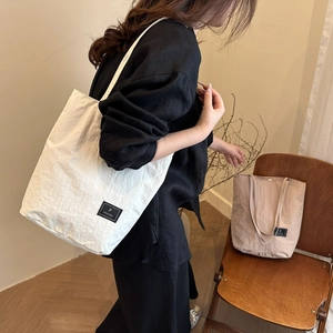 Minimalist large canvas bucket tote bag in white and beige with square brand label