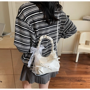 Detailed back view of white PU leather crossbody bag with bows and lace ribbons on a model