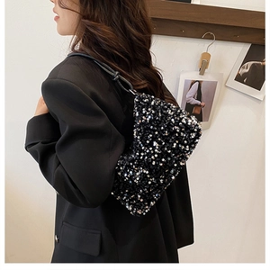 Detail of high-density black sequin shoulder bag with leather strap on a model