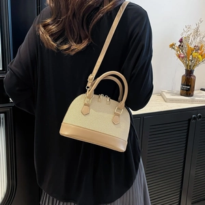 Vintage beige shell handbag with brown leather base shown in a modern lifestyle setting