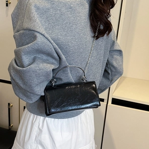 Modische schwarze glänzende Mini-Umhängetasche mit silbernem Metallgriff und Kette