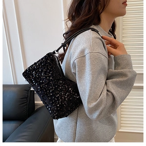 Close-up of black sequined shoulder bag showing detailed reflective texture and strap