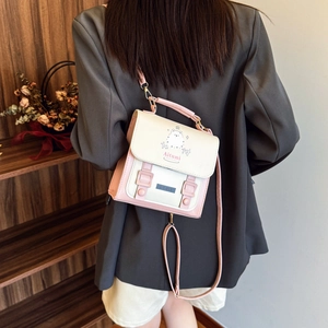 Pink and beige crossbody bag with dog illustration and adjustable strap shown on model
