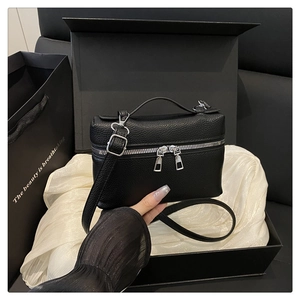 Detail of black lychee leather vanity bag in a gift box with white satin lining