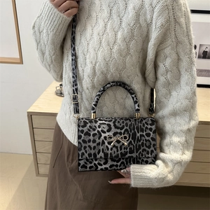 Minimalist leopard print crossbody square bag with gold bow clasp and shoulder strap