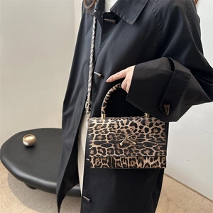 Leopard print crossbody handbag with golden bow detail and adjustable shoulder strap