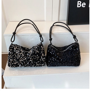 Detail of sequined shoulder bags with metallic finish and decorative knot handles