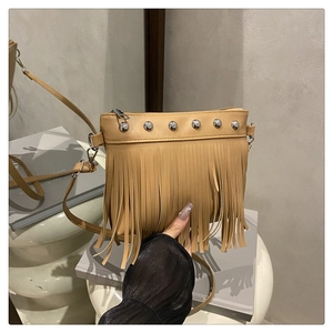 Détail du sac bandoulière en similicuir marron avec rivets argentés et longues franges