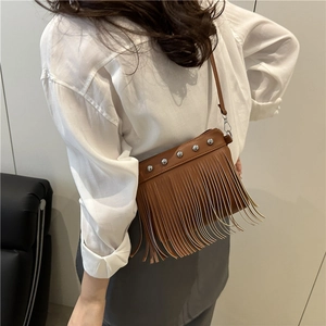 Sac bandoulière en cuir marron avec franges et clous argentés dans une vue décontractée
