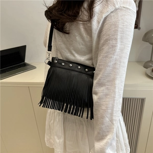 Sac bandoulière noir chic avec clous métalliques et longues franges sur l'épaule