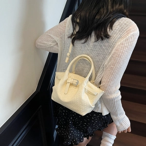 Borsa a secchiello chic bianco crema con trama a coccodrillo indossata da modella