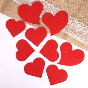 Détail de cœurs en feutrine rouge de tailles variées pour décoration murale de fête