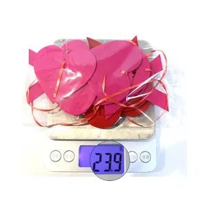 Close-up of red and fuchsia felt heart ornaments on scale weighing 23.9 grams