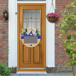 Detail of round wooden door hanger with blue finish and artificial greenery decor