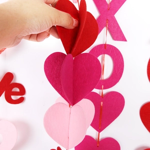Close-up of 3D folding red and pink felt heart garland for Valentine's party decor