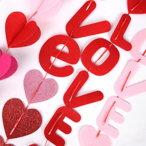Close-up of red and pink felt heart banners with LOVE letters for Valentine's decoration