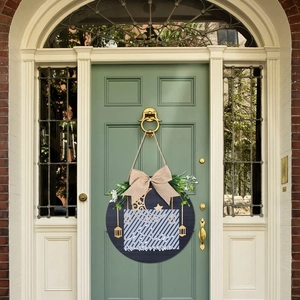 Wooden Ramadan Kareem hanging sign with moon and stars on a green front door
