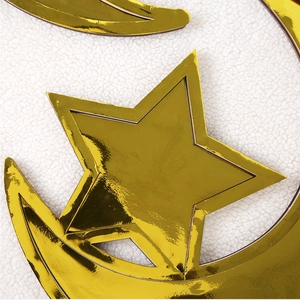 Makroaufnahme von goldenen Mond- und Stern-Dekorationen mit Spiegeleffekt auf Vlies