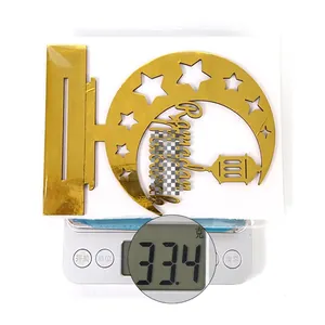 Golden acrylic Ramadan moon star decor weighing 33.4g on a digital scale for home display
