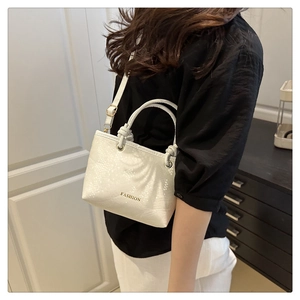 Detailed shot of white snake pattern leather bucket bag with gold fashion lettering