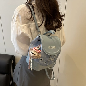Sac à dos en denim bleu clair minimaliste avec chaîne et breloque ours en peluche sur blanc