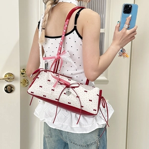 White coquette shoulder bag with red bow patterns and lace trim handle detail