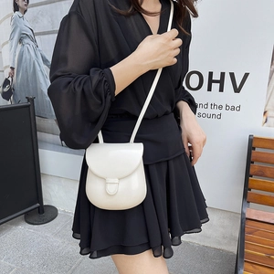 Classic cream semi-round crossbody saddle bag in glossy finish with slim shoulder strap