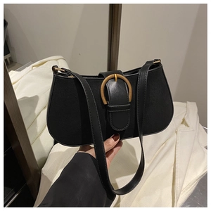 Detail of black canvas half-moon bag with leather strap and gold horseshoe buckle