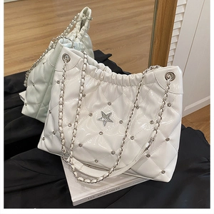Detail of white quilted chain bag with shiny patent leather and rhinestone star